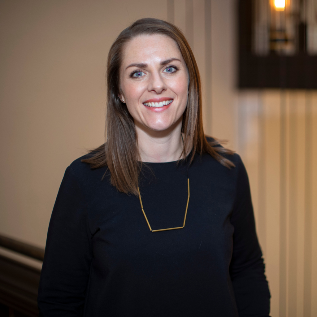 Headshot of Becky smiling towards camera wearing a plain black dress