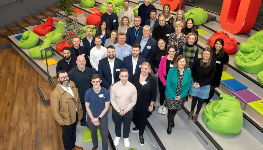Group image of people stood on steps looking up towards the camera.