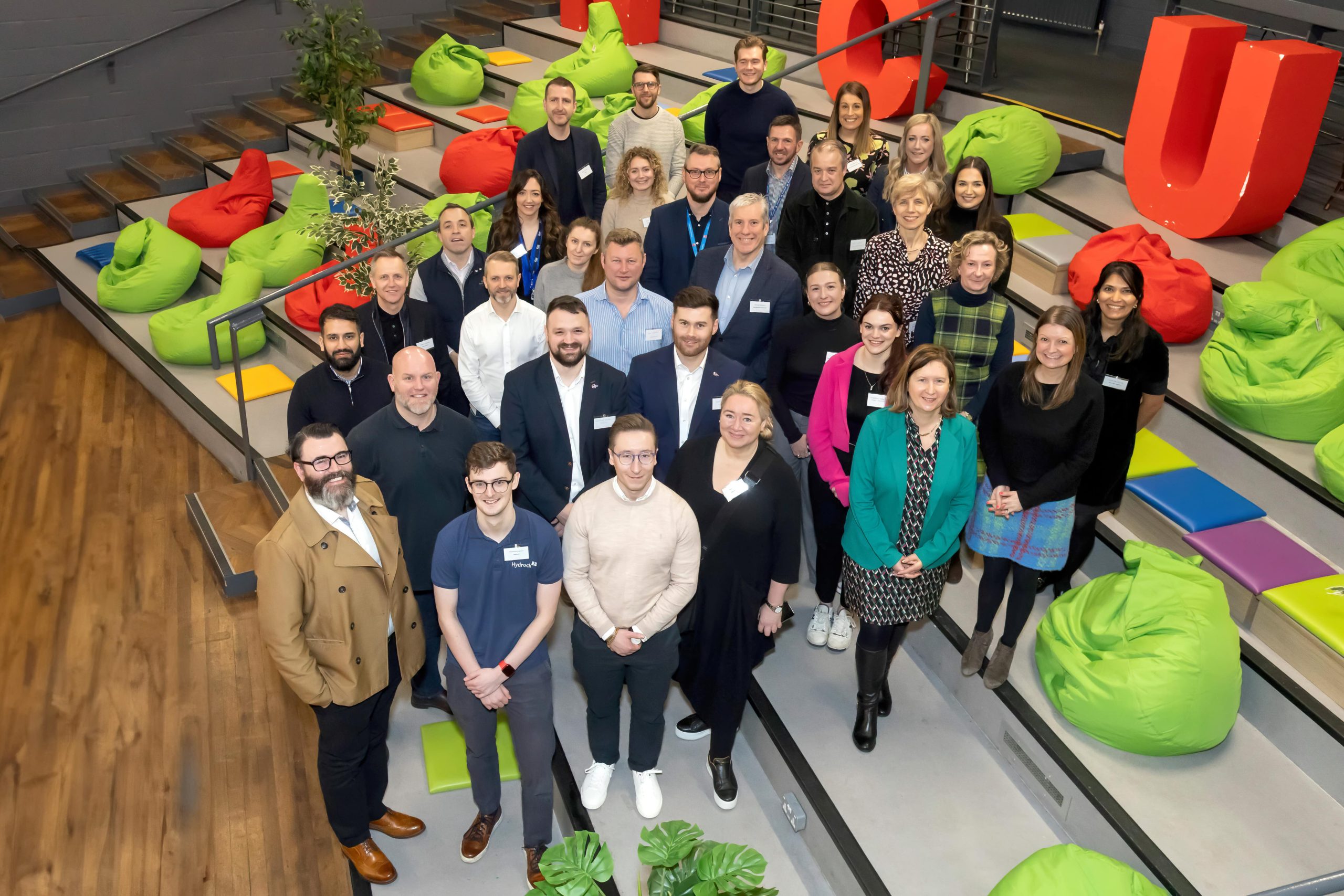 Group image of people stood on steps looking up towards the camera.